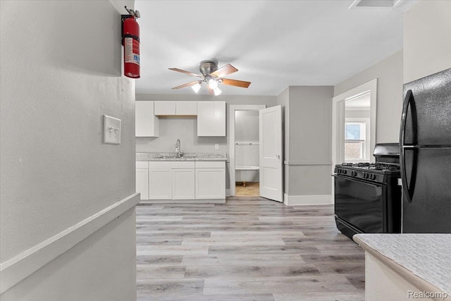 922 Maple, Wyandotte, MI 48192 - kitchen with black appliances, light countertops, white cabinetry, light wood-style flooring, and a ceiling fan