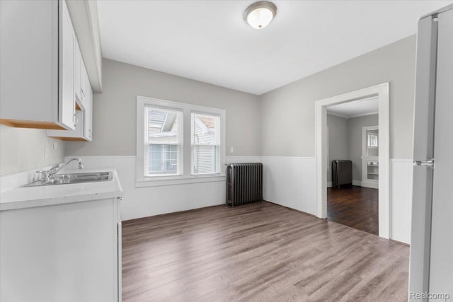922 Maple, Wyandotte, MI 48192 - unfurnished dining area with radiator, wood finished floors, and a wainscoted wall
