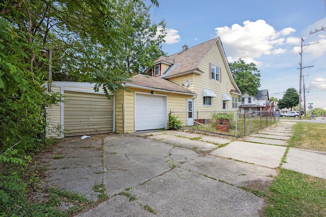 400 Burton St SW, Grand Rapids, MI 49507 - view of property exterior featuring a detached garage, a shingled roof, and driveway