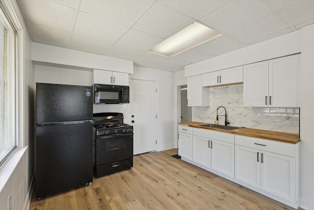 400 Burton St SW, Grand Rapids, MI 49507 - kitchen featuring black appliances, wooden counters, backsplash, light wood-type flooring, and white cabinetry