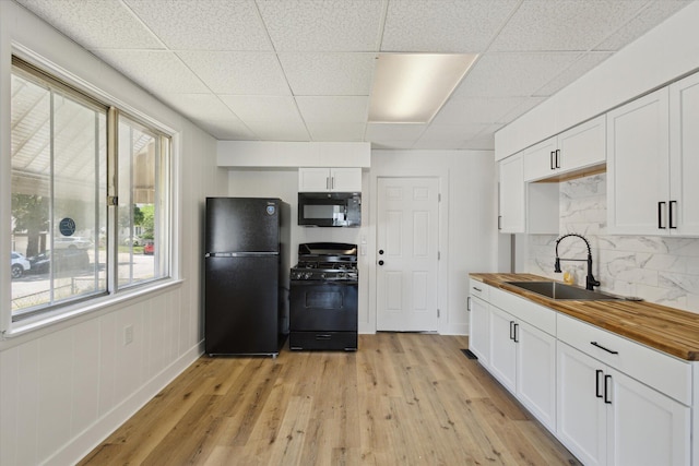400 Burton St SW, Grand Rapids, MI 49507 - kitchen featuring black appliances, wooden counters, a paneled ceiling, backsplash, and light wood-style flooring