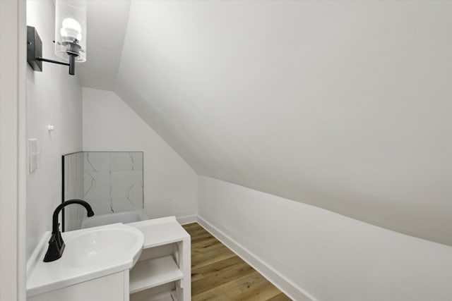400 Burton St SW, Grand Rapids, MI 49507 - bathroom featuring vaulted ceiling, vanity, and wood finished floors