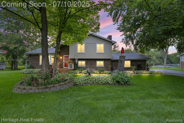 5021 Paula Ave, Clarkston, MI 48346 - split level home featuring brick siding, a front yard, and a chimney