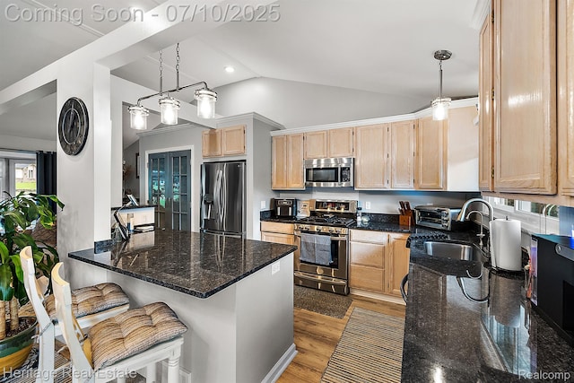 5021 Paula Ave, Clarkston, MI 48346 - kitchen featuring stainless steel appliances, light brown cabinetry, lofted ceiling, dark stone countertops, and a peninsula