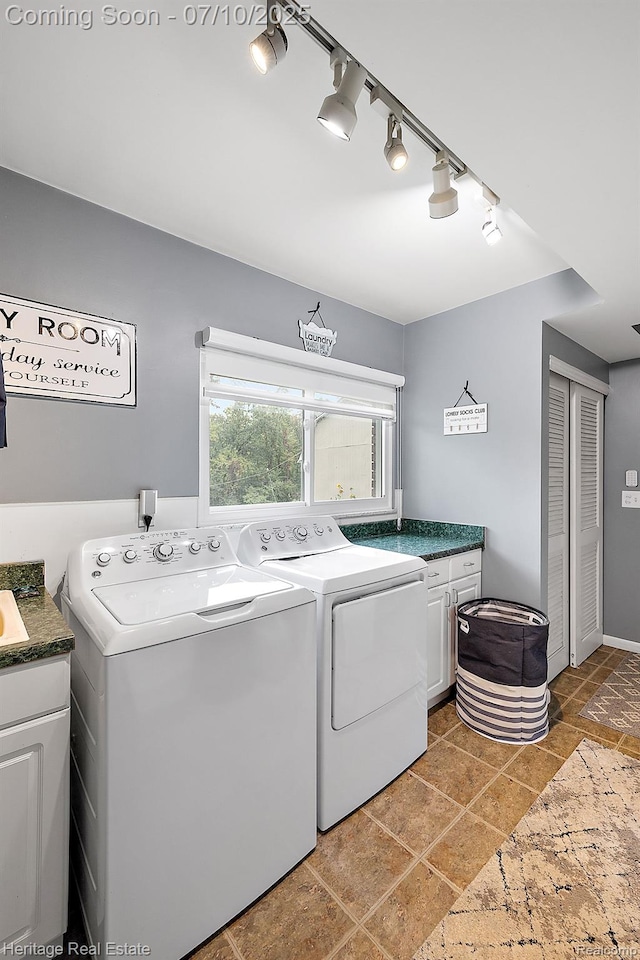 5021 Paula Ave, Clarkston, MI 48346 - laundry area with cabinet space, washing machine and clothes dryer, track lighting, and stone tile flooring