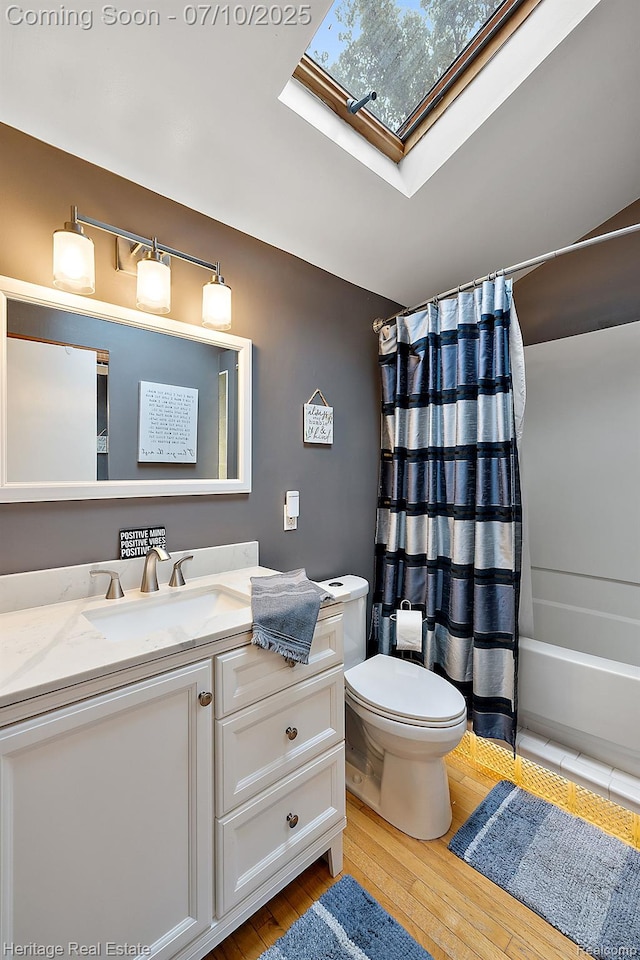 5021 Paula Ave, Clarkston, MI 48346 - bathroom featuring a skylight, vanity, hardwood / wood-style flooring, and shower / tub combo with curtain