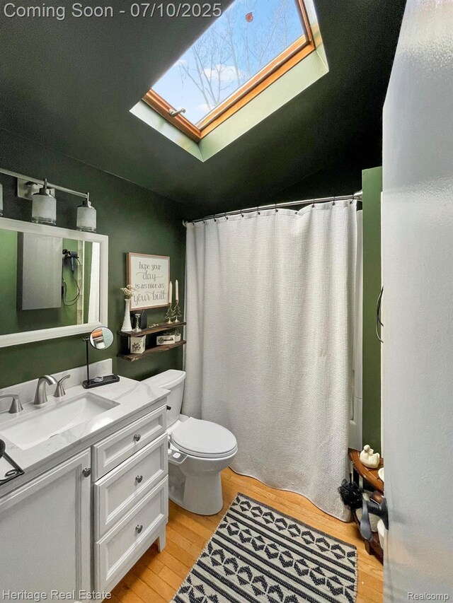 5021 Paula Ave, Clarkston, MI 48346 - bathroom featuring a skylight, wood finished floors, vanity, and a shower with shower curtain