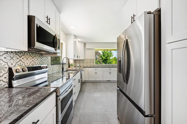 3017 Niles Buchanan Rd, Buchanan, MI 49107 - kitchen with appliances with stainless steel finishes, dark stone countertops, tasteful backsplash, white cabinets, and recessed lighting
