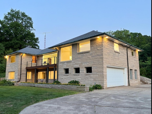 3017 Niles Buchanan Rd, Buchanan, MI 49107 - rear view of property featuring stone siding, a balcony, an attached garage, concrete driveway, and a yard