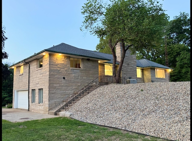 3017 Niles Buchanan Rd, Buchanan, MI 49107 - view of side of home with stone siding, an attached garage, a chimney, stairs, and driveway