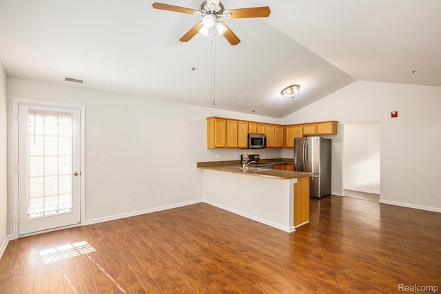 12129 Hidden View Ct, Utica, MI 48315 - kitchen with stainless steel appliances, a peninsula, lofted ceiling, a ceiling fan, and dark wood finished floors