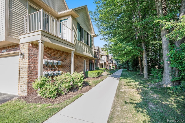 12129 Hidden View Ct, Utica, MI 48315 - view of side of home with a balcony, a garage, and brick siding