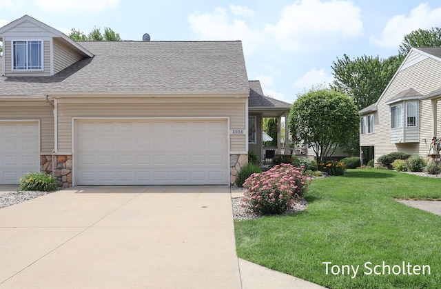 2956 Pebblestone Dr Unit 47, Hudsonville, MI 49426 - view of front of home featuring stone siding, driveway, roof with shingles, a front yard, and an attached garage