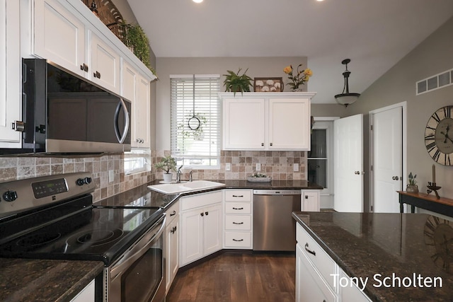 2956 Pebblestone Dr Unit 47, Hudsonville, MI 49426 - kitchen with stainless steel appliances, decorative backsplash, lofted ceiling, dark wood-style floors, and white cabinetry