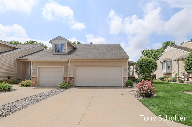 2956 Pebblestone Dr Unit 47, Hudsonville, MI 49426 - view of front facade featuring stone siding, a garage, driveway, a front lawn, and roof with shingles