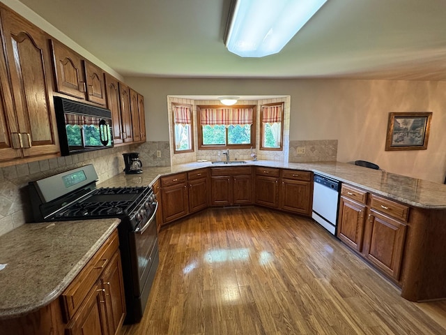 70173 Hillside Ct, Romeo, MI 48065 - kitchen featuring gas range, black microwave, dishwasher, a peninsula, and wood finished floors