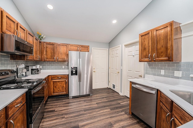 8191 Creekside Dr, Westland, MI 48185 - kitchen with appliances with stainless steel finishes, lofted ceiling, dark wood-style floors, light countertops, and backsplash