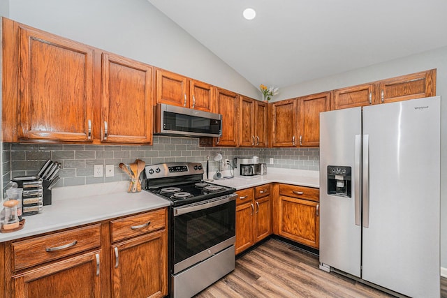 8191 Creekside Dr, Westland, MI 48185 - kitchen featuring appliances with stainless steel finishes, lofted ceiling, light countertops, light wood-style flooring, and tasteful backsplash