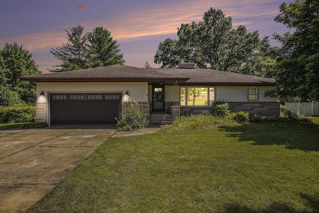 8520 Pennfield Rd, Battle Creek, MI 49017 - view of front facade featuring a garage, concrete driveway, a front lawn, stone siding, and a chimney
