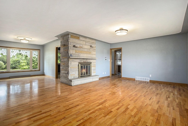 8520 Pennfield Rd, Battle Creek, MI 49017 - unfurnished living room with light wood-style flooring and a stone fireplace
