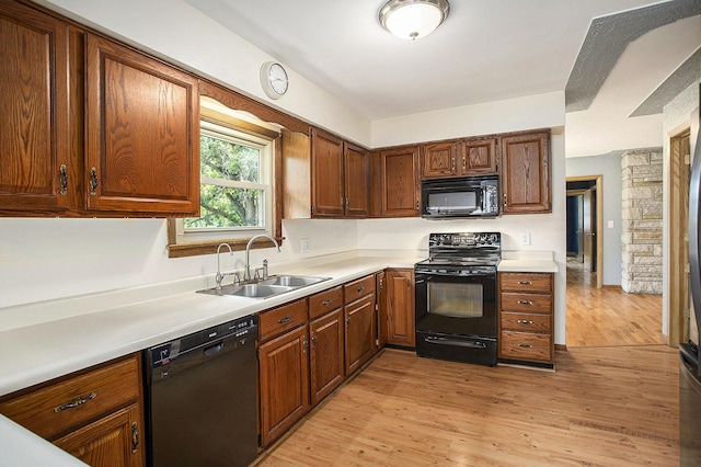 8520 Pennfield Rd, Battle Creek, MI 49017 - kitchen featuring black appliances, light wood-style flooring, light countertops, and brown cabinets