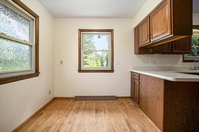 8520 Pennfield Rd, Battle Creek, MI 49017 - kitchen featuring light wood-type flooring, light countertops, and brown cabinets