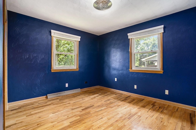 8520 Pennfield Rd, Battle Creek, MI 49017 - empty room with a baseboard radiator, plenty of natural light, and wood finished floors