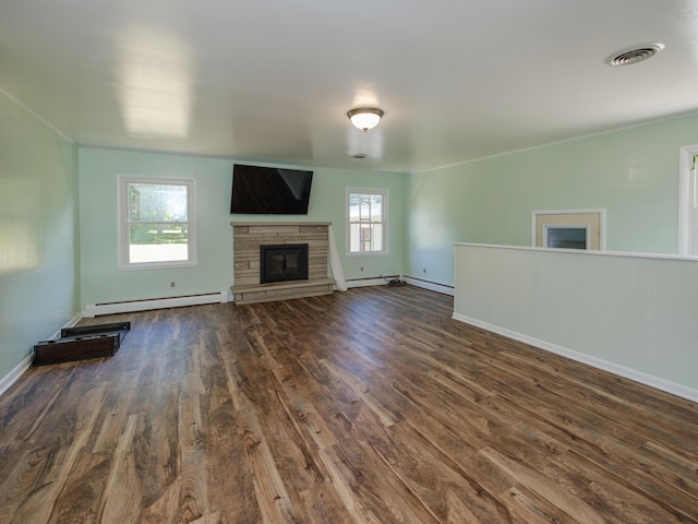 4409 E T U Ave, Vicksburg, MI 49097 - unfurnished living room featuring a baseboard radiator, a stone fireplace, and dark wood-type flooring
