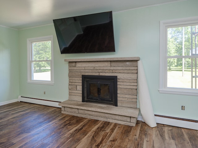 4409 E T U Ave, Vicksburg, MI 49097 - detailed view of baseboard heating, wood finished floors, crown molding, and a stone fireplace