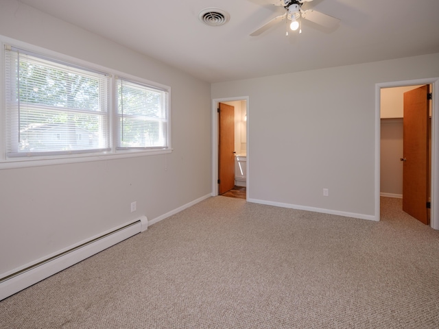 4409 E T U Ave, Vicksburg, MI 49097 - unfurnished bedroom featuring a baseboard radiator, light carpet, ensuite bathroom, and a walk in closet