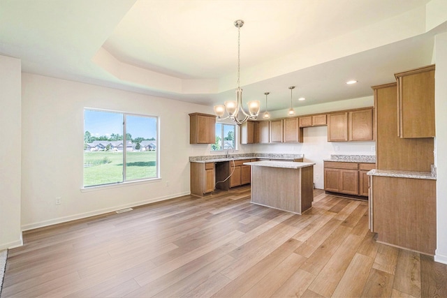 5391 Swan Ln, Burton, MI 48509 - kitchen with dishwashing machine, a chandelier, a kitchen island, light wood-style flooring, and a raised ceiling