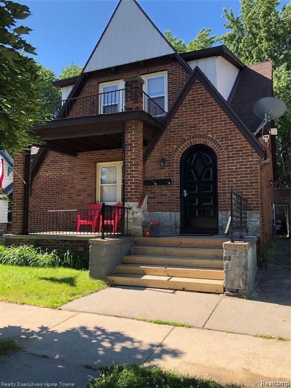 1112 Minnie St, Port Huron, MI 48060 - view of front of property with a balcony, brick siding, covered porch, and board and batten siding