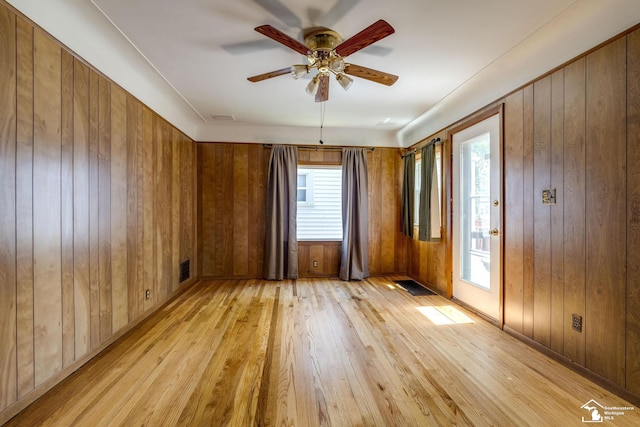 917 E 8th St, Monroe, MI 48161 - empty room with light wood-style flooring, a ceiling fan, and wood walls