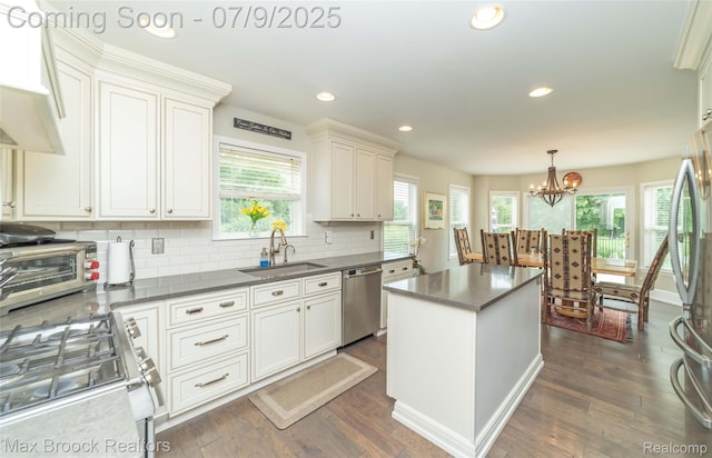 1478 Courtney Ct, Hartland, MI 48353 - kitchen featuring appliances with stainless steel finishes, a kitchen island, dark wood-type flooring, decorative backsplash, and a chandelier
