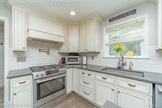 1478 Courtney Ct, Hartland, MI 48353 - kitchen with stainless steel appliances, decorative backsplash, custom exhaust hood, dark wood-style flooring, and white cabinetry