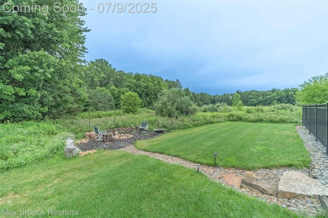 1478 Courtney Ct, Hartland, MI 48353 - view of green lawn with an outdoor fire pit and a view of trees