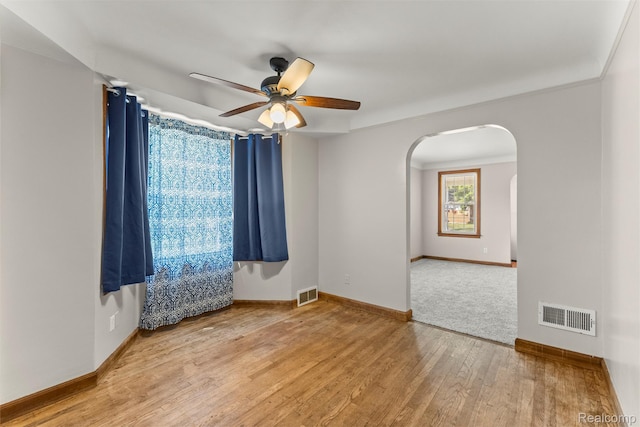 785 Tromley St, Inkster, MI 48141 - spare room featuring arched walkways, a ceiling fan, and wood finished floors