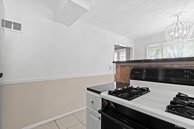 4200 Lois St, Dearborn, MI 48126 - kitchen with black range with gas cooktop, light tile patterned flooring, a chandelier, a textured ceiling, and hanging light fixtures
