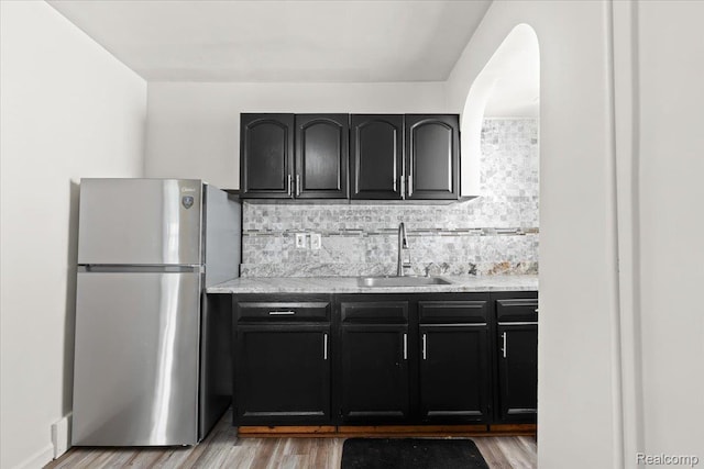 4200 Lois St, Dearborn, MI 48126 - kitchen with freestanding refrigerator, light wood-type flooring, tasteful backsplash, and dark cabinets