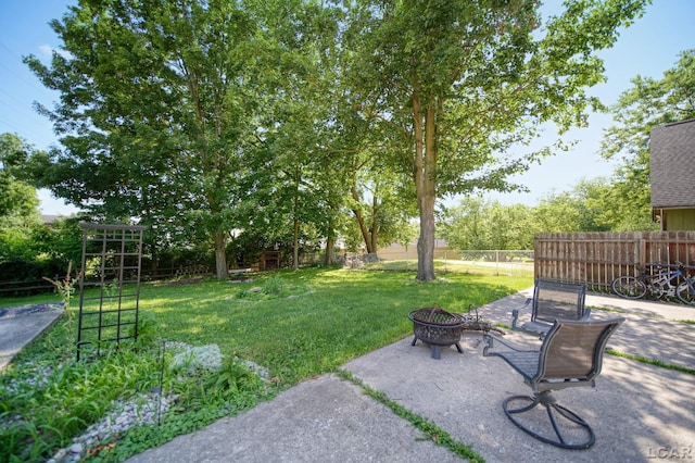 317 Clark St, Clinton, MI 49236 - fenced backyard featuring a fire pit and a patio area