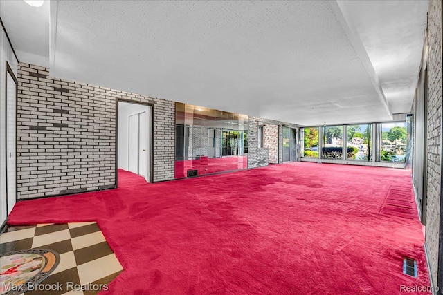 2840 Wall St, Keego Harbor, MI 48320 - interior space featuring carpet floors, a textured ceiling, and brick wall