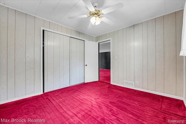 2840 Wall St, Keego Harbor, MI 48320 - unfurnished bedroom featuring carpet, wooden walls, a closet, and ceiling fan
