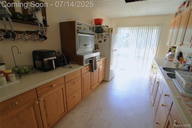 116 N Shiawassee St, Bancroft, MI 48414 - kitchen featuring freestanding refrigerator, light countertops, light flooring, and brown cabinetry