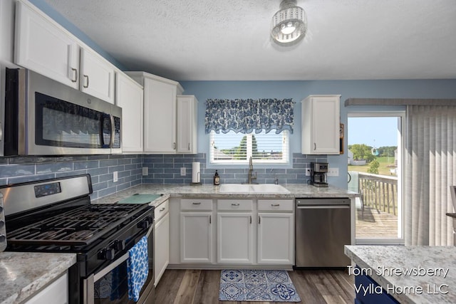 1698 Trent Ridge Ct NE, Cedar Springs, MI 49319 - kitchen featuring appliances with stainless steel finishes, white cabinets, dark wood-style floors, and a textured ceiling