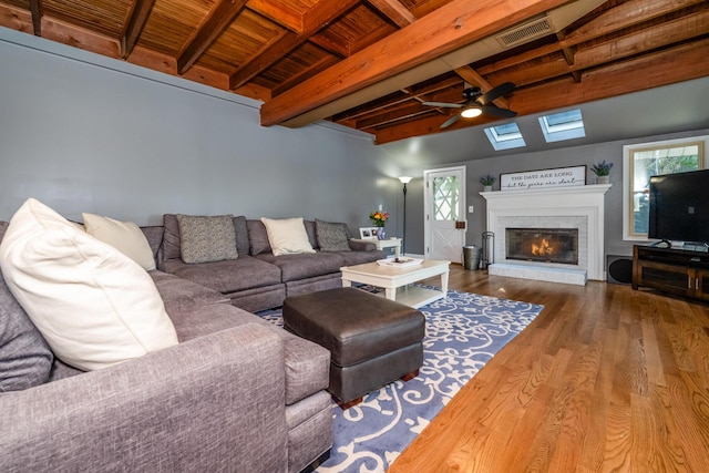 5680 Woodland Ave, Watervliet, MI 49098 - living area featuring wood finished floors, a wooden ceiling with exposed beams, a glass covered fireplace, and ceiling fan