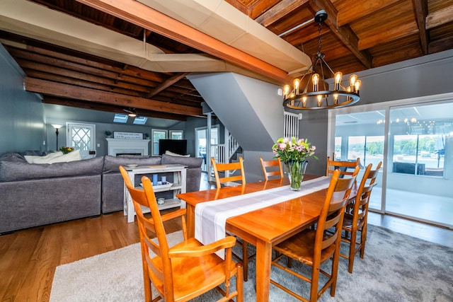 5680 Woodland Ave, Watervliet, MI 49098 - dining space with a wood ceiling with exposed beams, wood finished floors, a chandelier, healthy amount of natural light, and a fireplace