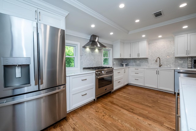 5680 Woodland Ave, Watervliet, MI 49098 - kitchen featuring appliances with stainless steel finishes, extractor fan, light wood-style flooring, backsplash, and crown molding