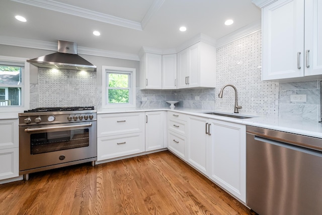 5680 Woodland Ave, Watervliet, MI 49098 - kitchen featuring stainless steel appliances, wall chimney exhaust hood, light countertops, light wood-style floors, and white cabinets