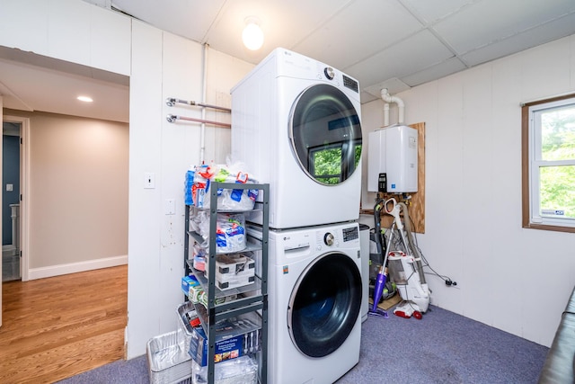 5680 Woodland Ave, Watervliet, MI 49098 - laundry room featuring stacked washer / drying machine, water heater, and wood finished floors