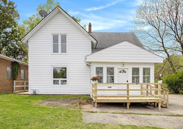 22121 Bedford Rd N, Battle Creek, MI 49017 - rear view of house featuring a wooden deck, a chimney, and a lawn